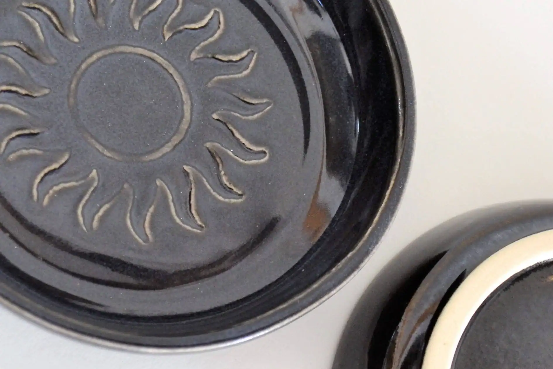 appetizer plate, black with sun stamp in middle