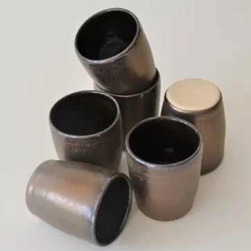 a collection of bronze pottery shot glasses